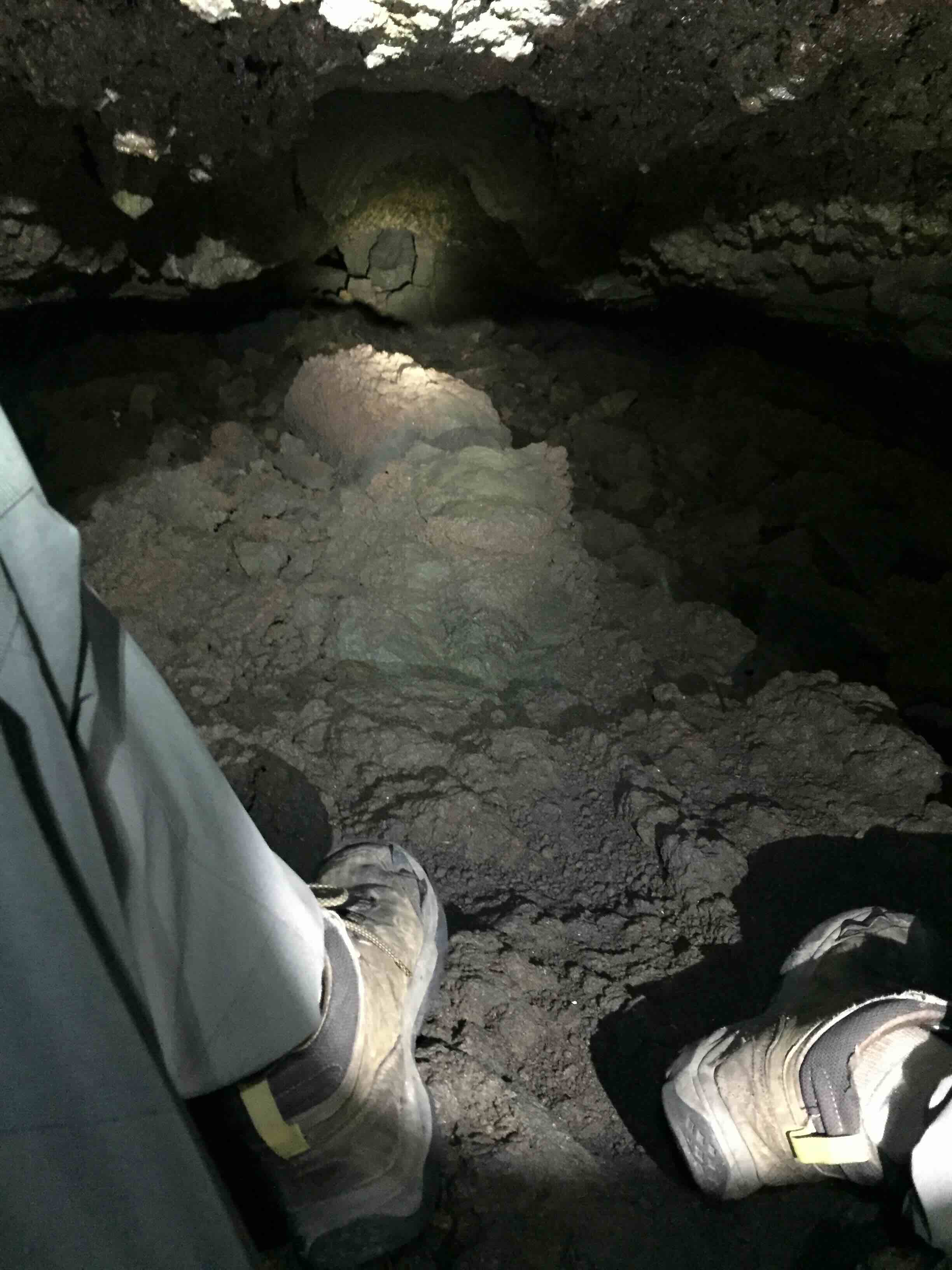 tight cave passage with feet visible