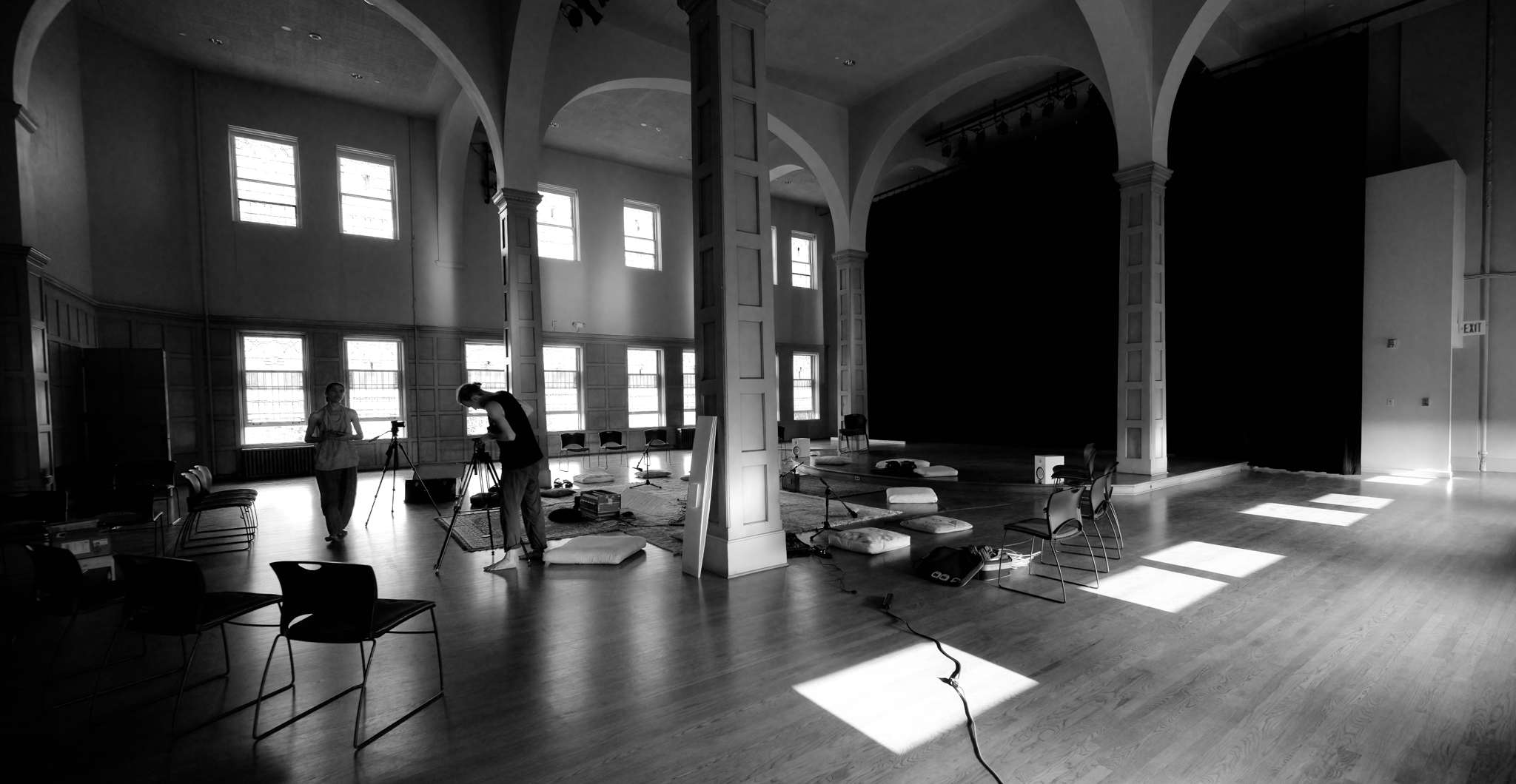 Wide view of empty performance hall during setup with equipment and rugs