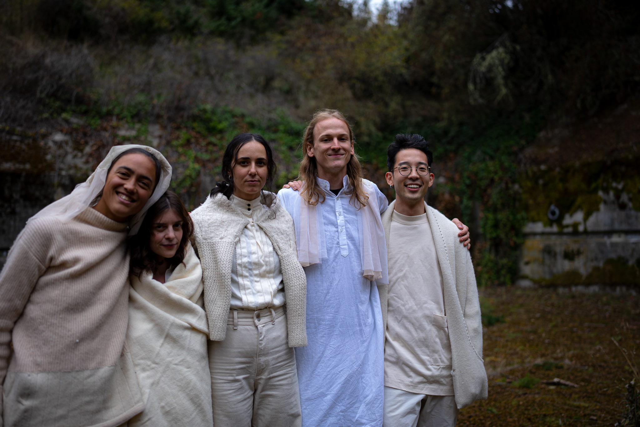 Five performers standing outdoors in natural setting at Fort Worden