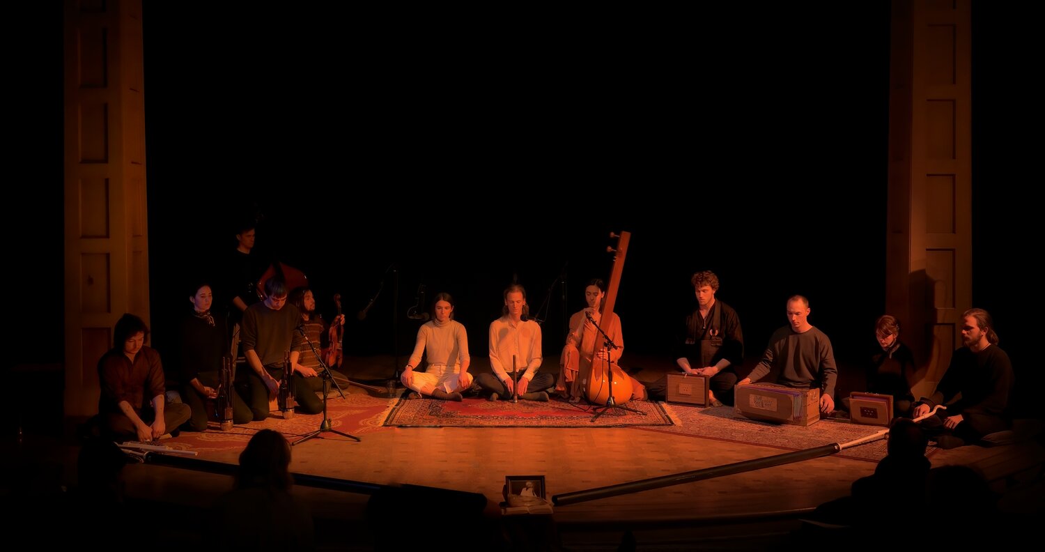 Full ensemble seated on stage