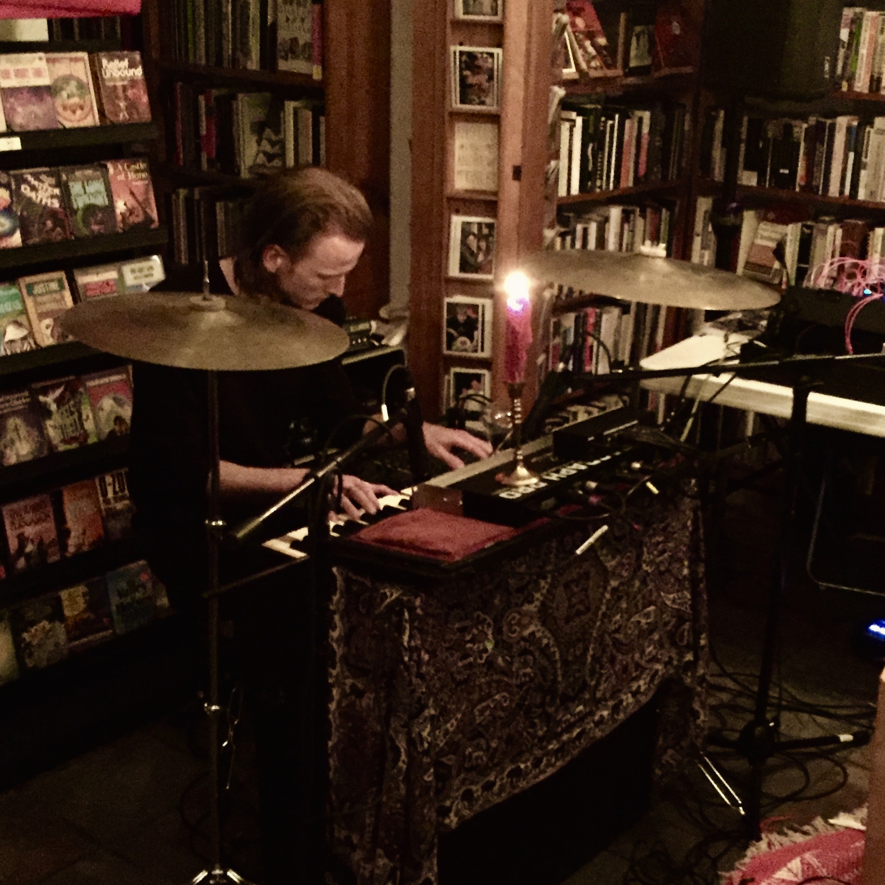 Performing reed organ surrounded by books and candlelight