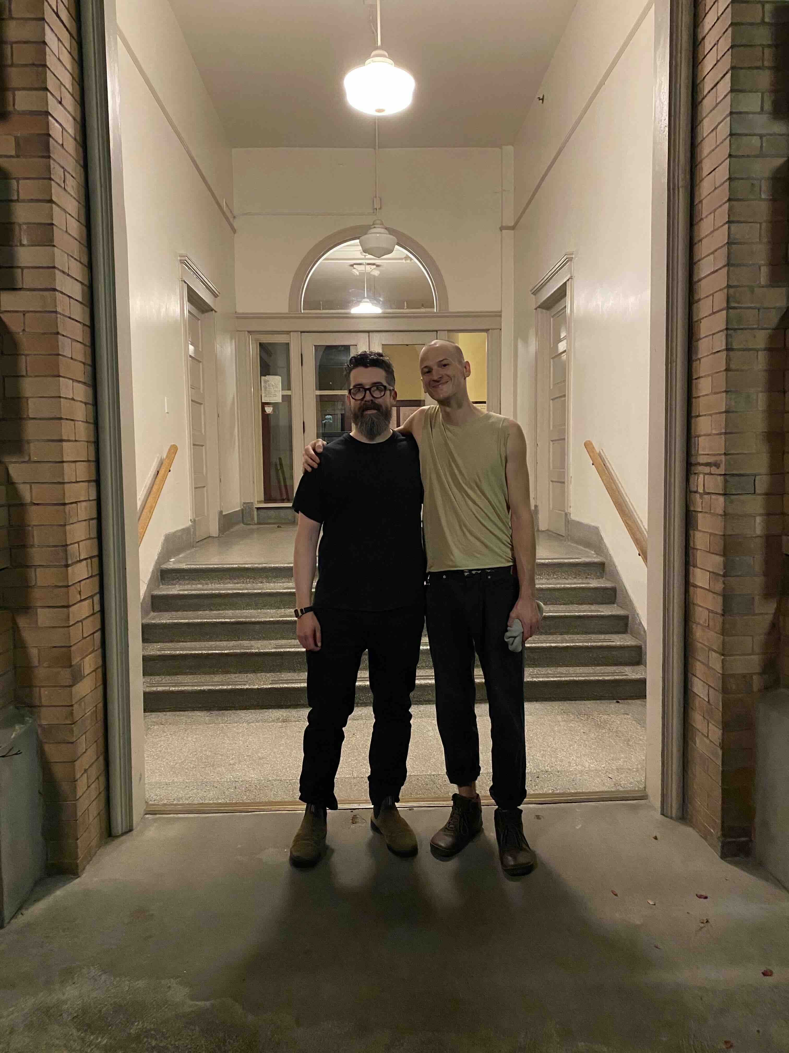 Joey Largent and Nat Evans standing together inside Chapel Performance Space after a concert